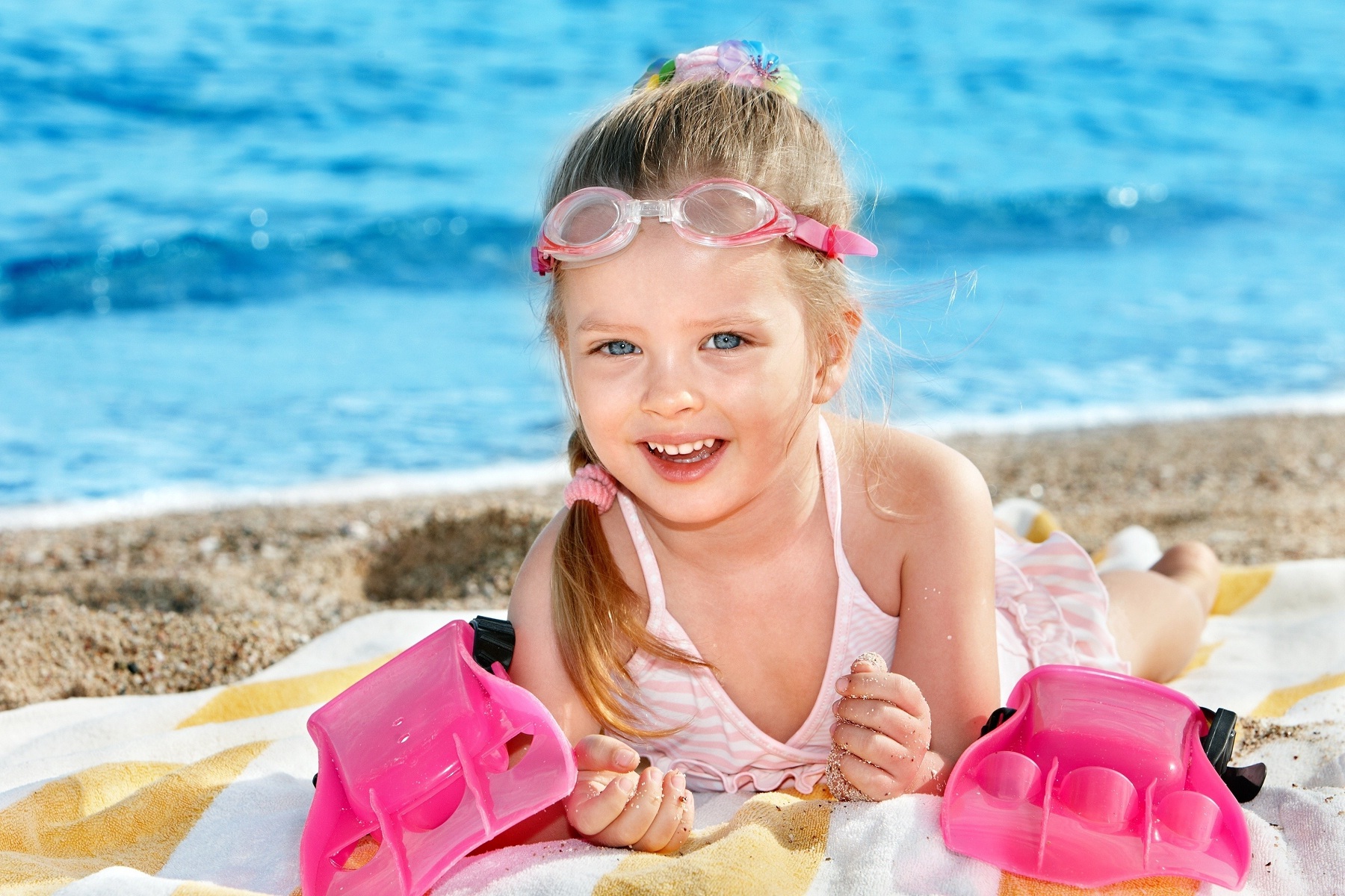Smiling face of cute baby girl on beach